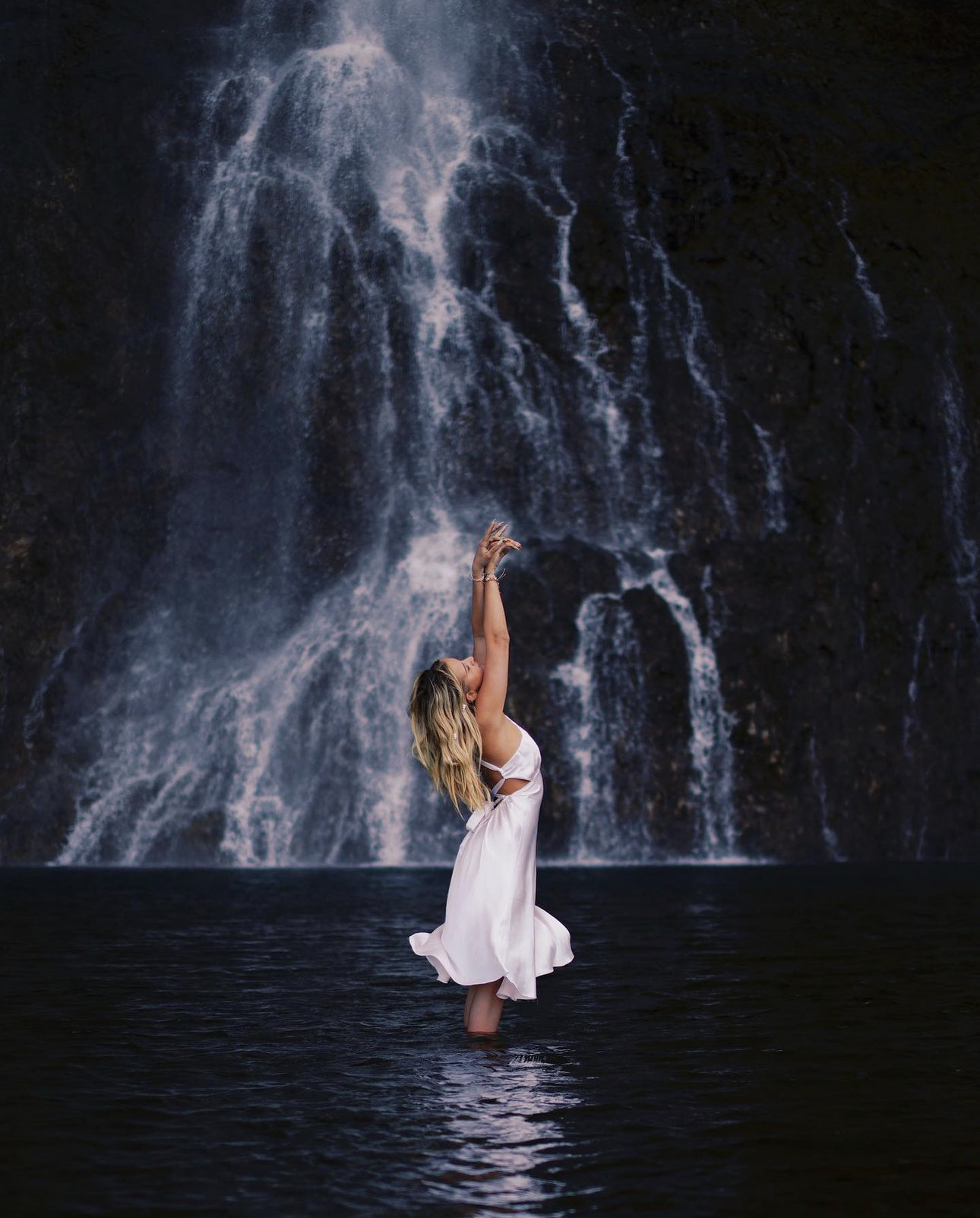 Marla Posing in a white dress in front of a waterfall